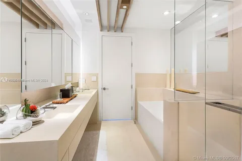 a bathroom with a tub sink a mirror and a shower