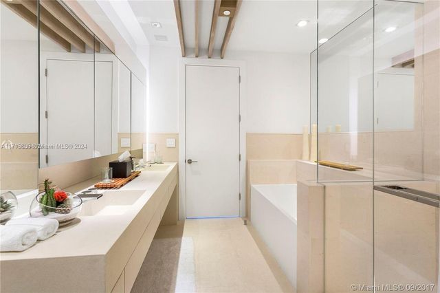 a bathroom with a tub sink a mirror and a shower