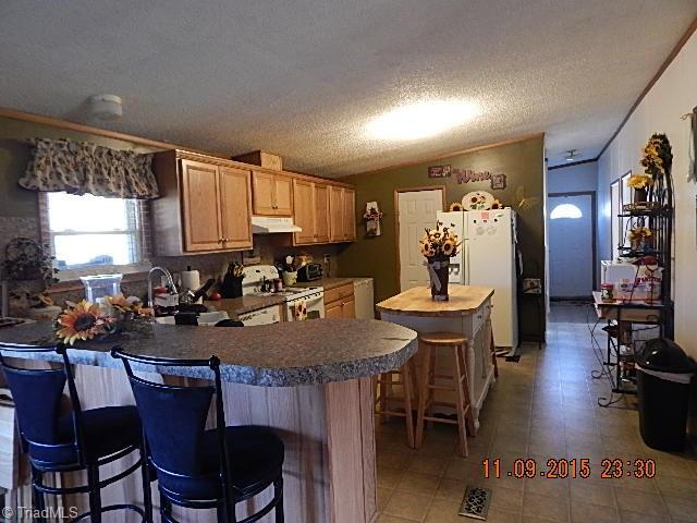 1036 Barn Road Walnut Cove, NC 27052 - Photo 4 of 24 The kitchen has eat-at bar, island, and pantry.