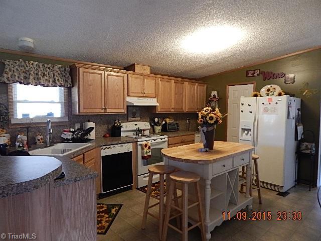 1036 Barn Road Walnut Cove, NC 27052 - Photo 5 of 24 Newer cabinets, countertops, vinyl floor, and new faucet.
