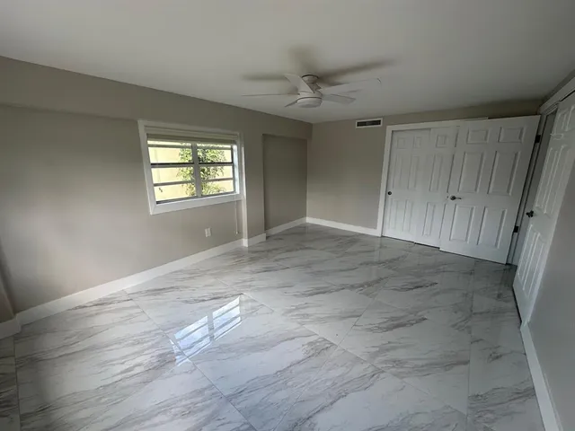 an empty room with windows and closet