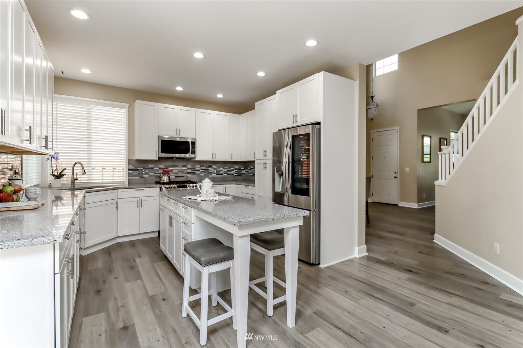 28035 Maple Ridge Way Southeast Maple Valley, WA 98038 - Photo 12 of 40 a kitchen with white cabinets and stainless steel appliances