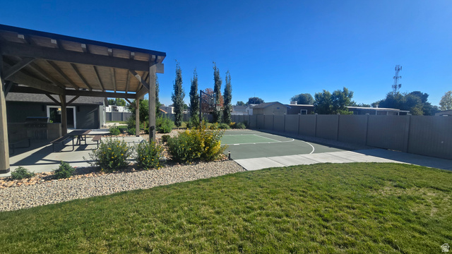 1500 Angel Street North, Unit 53 Layton, UT 84041 - Photo 17 of 20 Expansive backyard featuring a covered patio, concrete paving, a manicured lawn, and a sport court