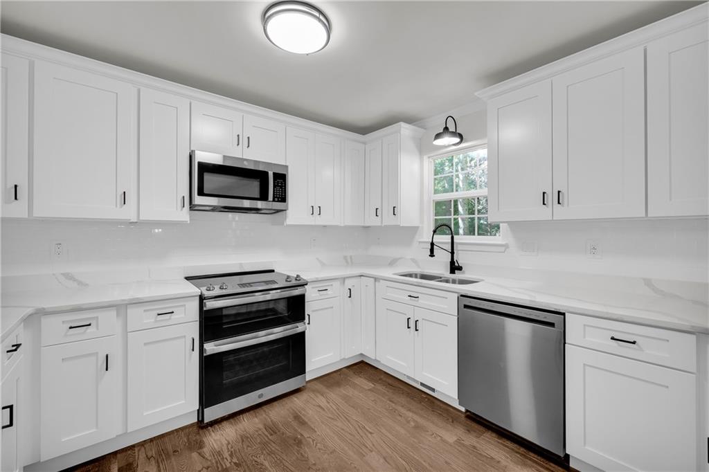 2941 Lake Hollow Road Gainesville, GA 30501 - Photo 14 of 53 a kitchen with white cabinets appliances and a sink