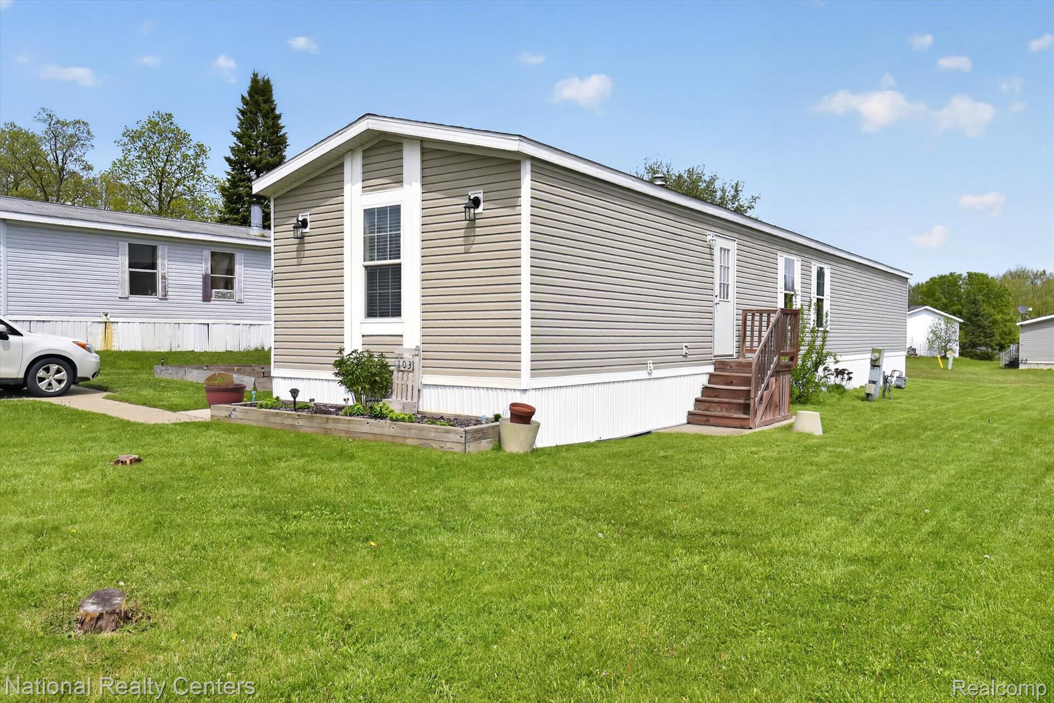 2735 South Wagner Road, Unit 103 Ann Arbor, MI 48103 - Photo 2 of 20 Back of property with a lawn and a garden