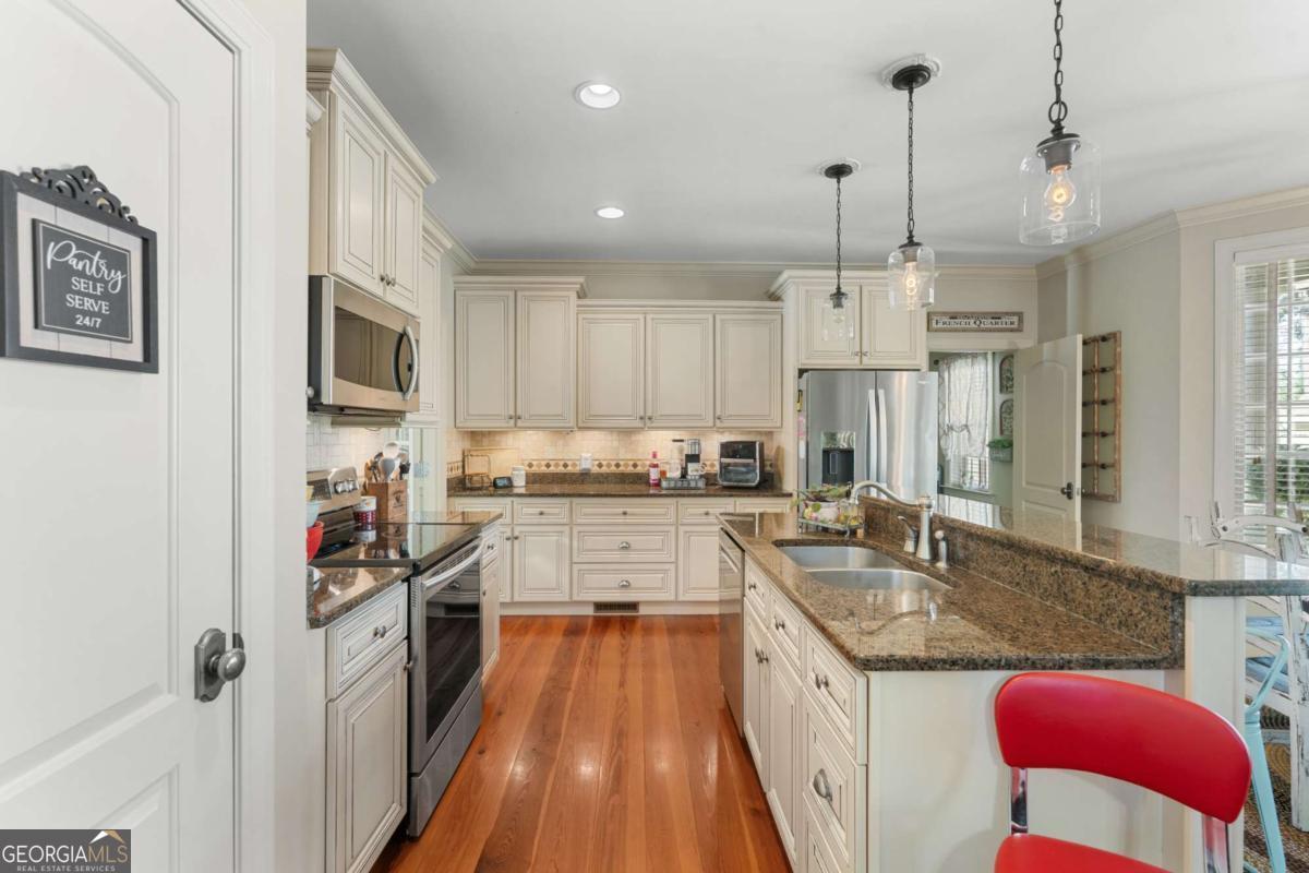 201 Walthour Drive Rincon, GA 31326 - Photo 9 of 29 a kitchen with stainless steel appliances granite countertop a sink stove and refrigerator