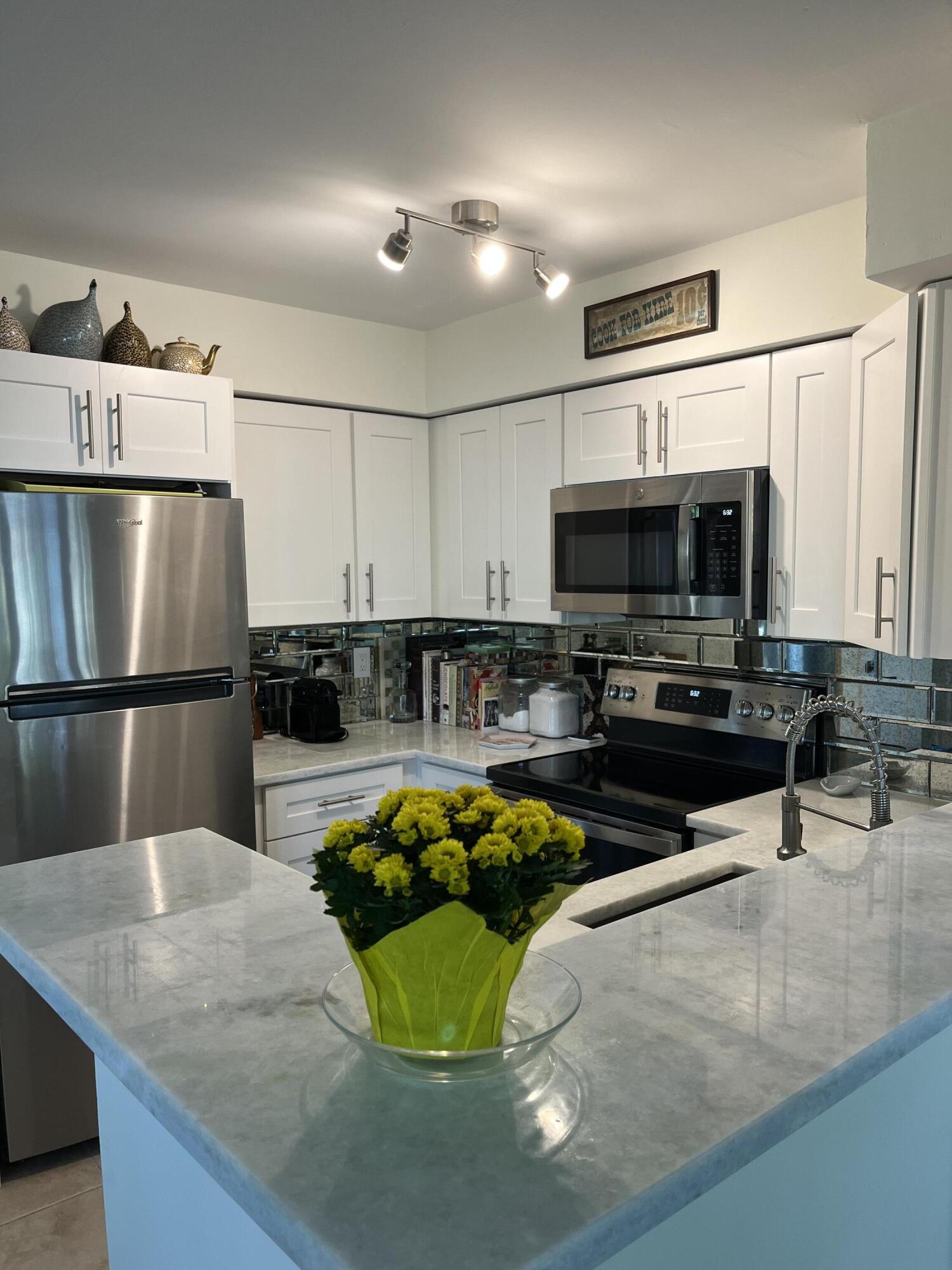 a kitchen with stainless steel appliances granite countertop a sink a stove and a microwave