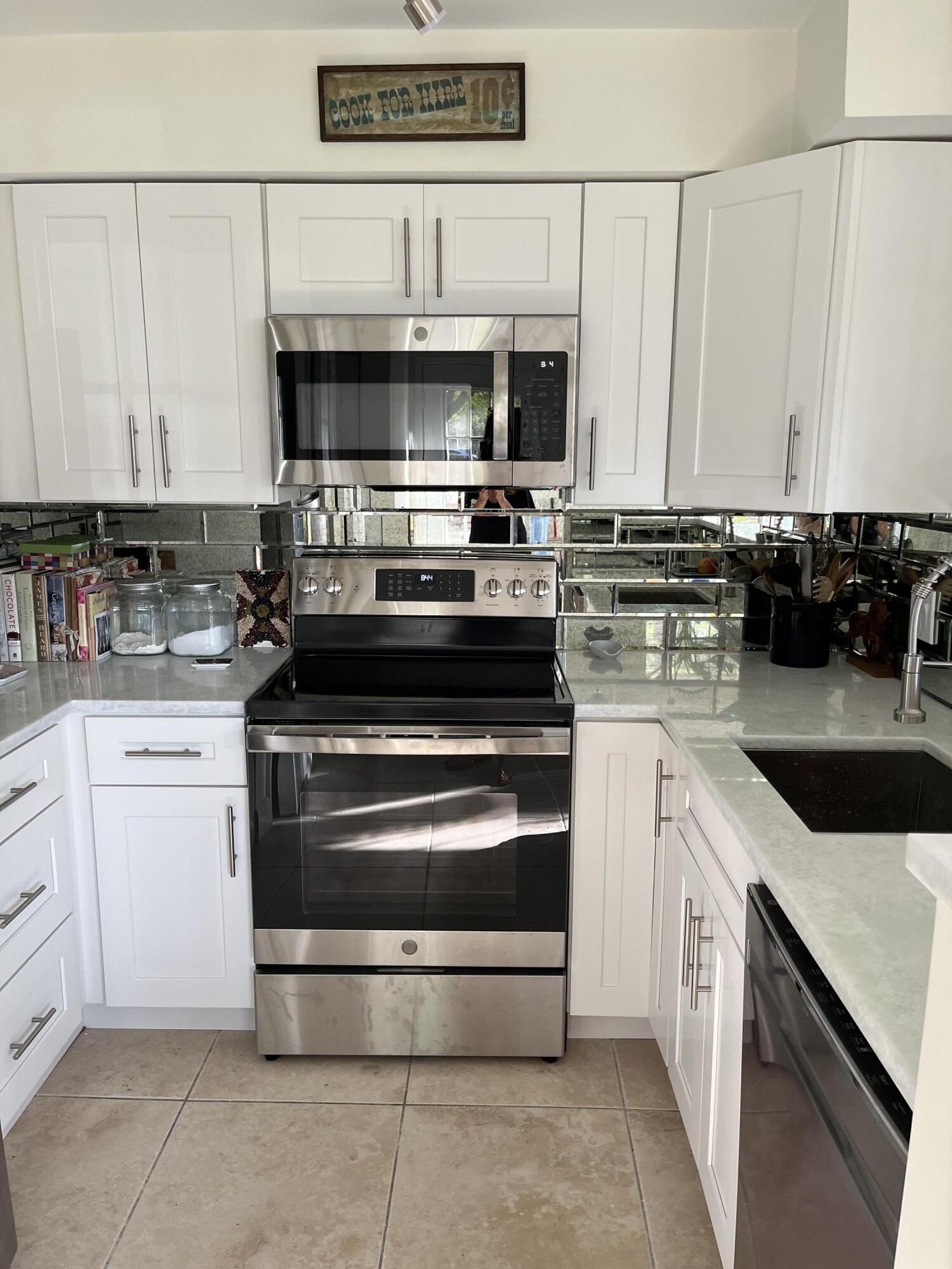 1001 Crystal Way, Unit A Delray Beach, FL 33444 - Photo 3 of 10 a kitchen with stainless steel appliances granite countertop a stove and a microwave