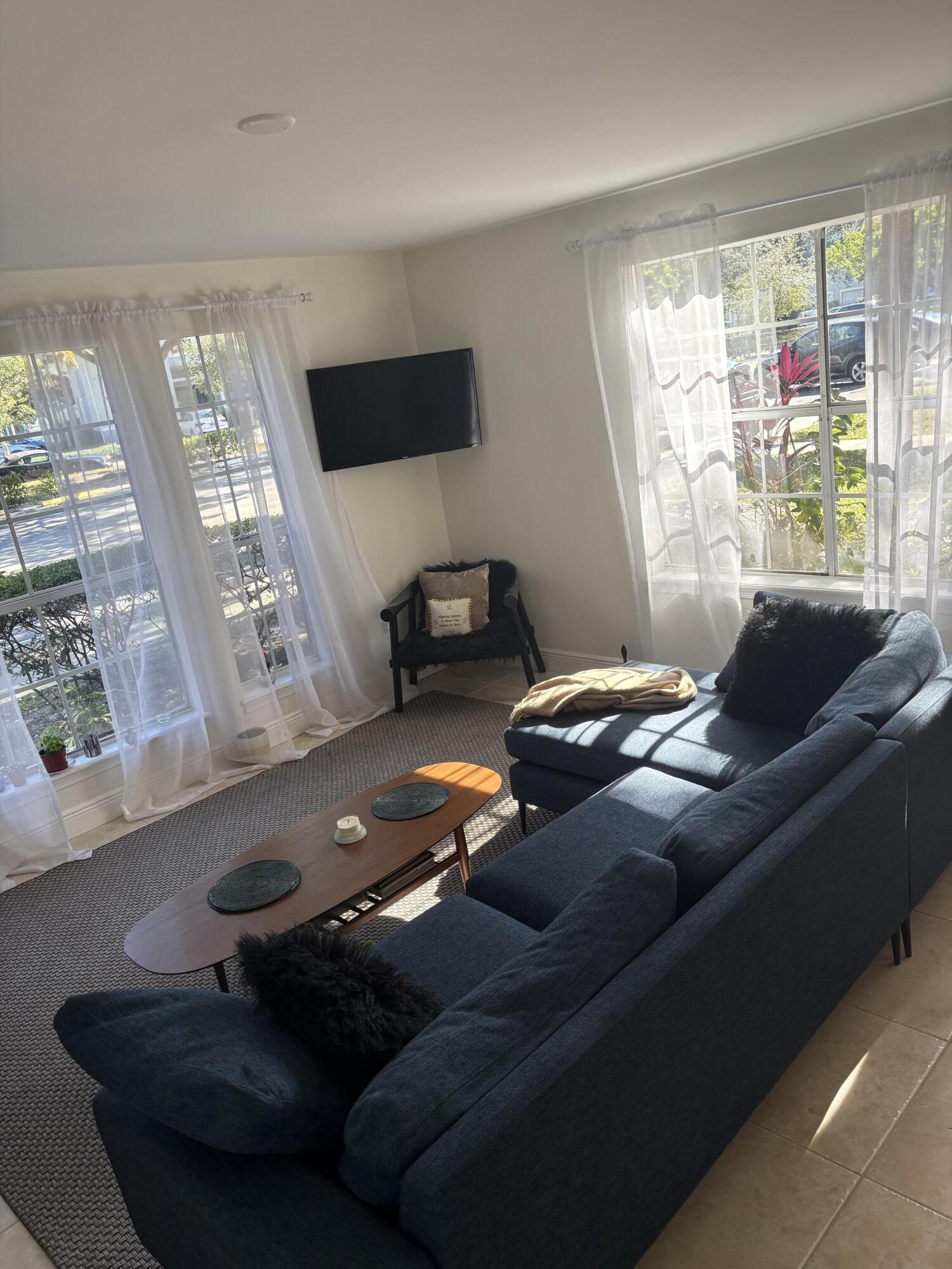 1001 Crystal Way, Unit A Delray Beach, FL 33444 - Photo 5 of 10 a living room with furniture and a flat screen tv