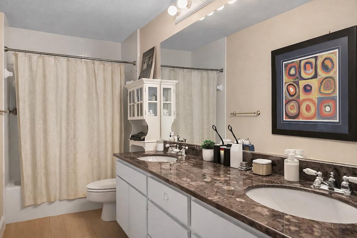 20952 Delagado Terrace Boca Raton, FL 33433 - Photo 17 of 27 a bathroom with double vanity sinks a toilet a mirror and a shower