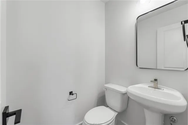 a bathroom with a sink mirror and toilet