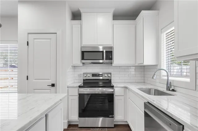 a kitchen with a sink stove and microwave