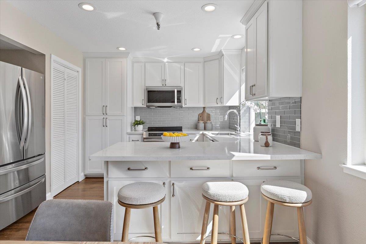 363 North Rengstorff Avenue, Unit 5 Mountain View, CA 94043 - Photo 13 of 35 a kitchen with stainless steel appliances a dining table chairs sink and cabinets
