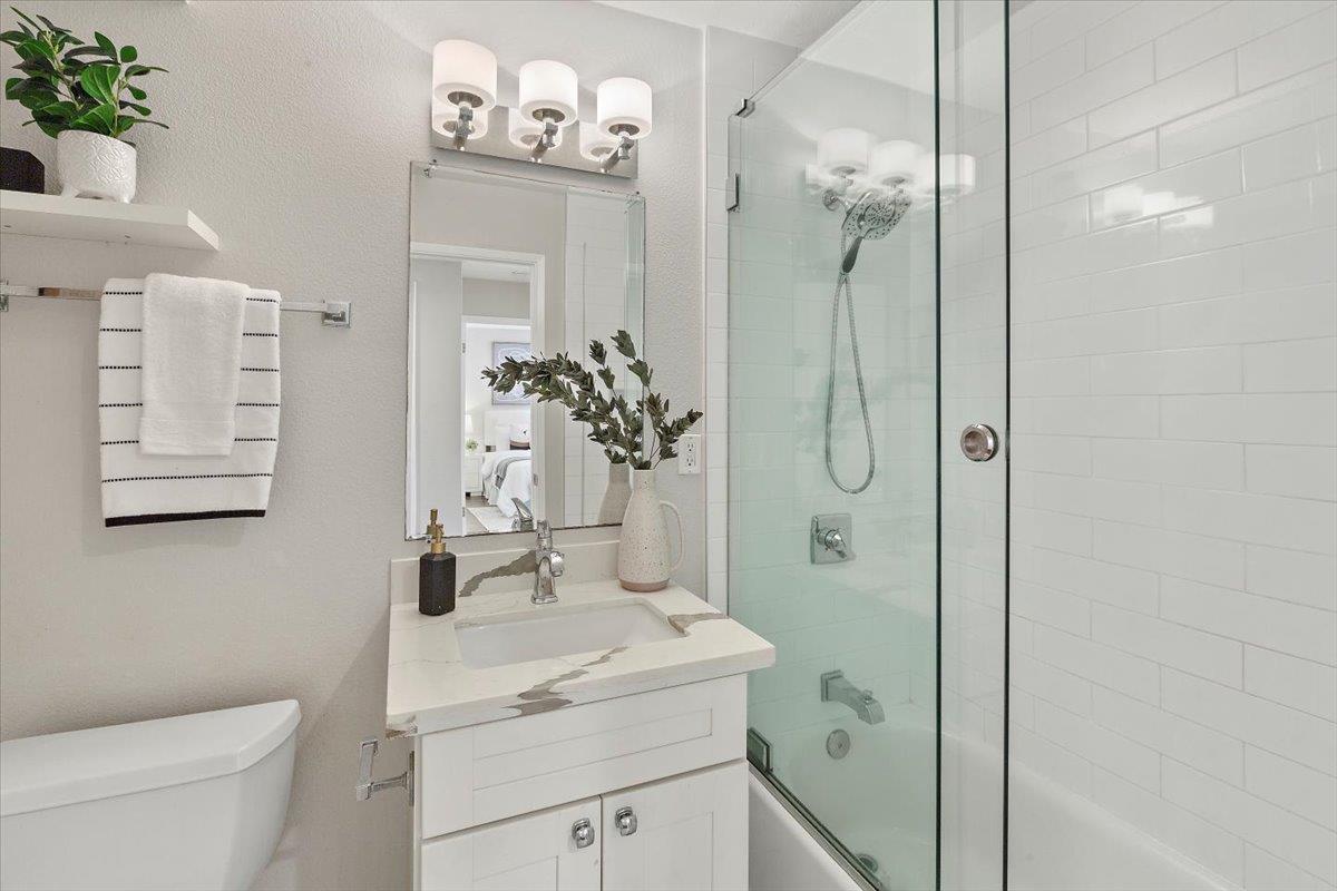363 North Rengstorff Avenue, Unit 5 Mountain View, CA 94043 - Photo 6 of 35 a bathroom with a granite countertop sink a toilet and shower