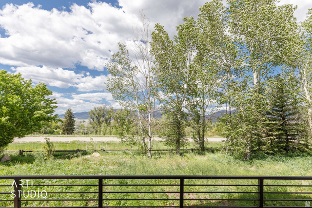 1188 South Old Trappers Loop Road Huntsville, UT 84317 - Photo 67 of 92 Expansive outdoor scenery featuring mature trees, a grassy field, and distant mountains under a blue sky with white clouds