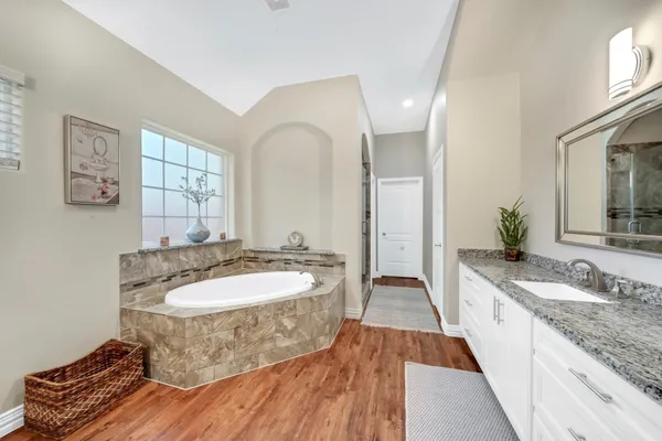 a spacious bathroom with a granite countertop sink and a mirror