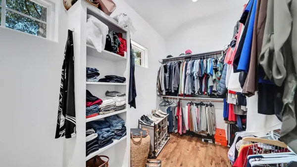 a view of walk in closet with clothes and shoes