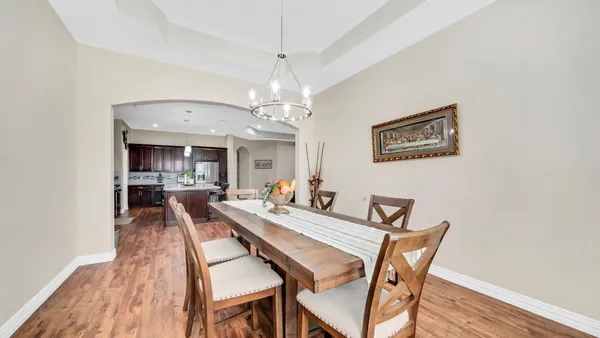 a view of a dining room with furniture wooden floor and chandelier
