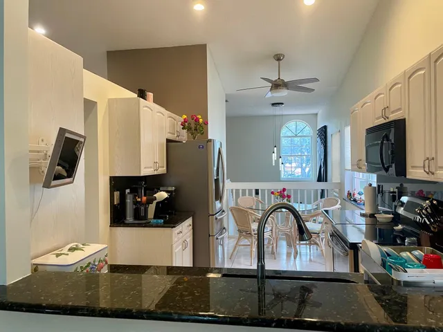 a living room with furniture a flat screen tv and kitchen view