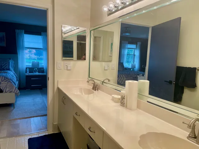 a en suite bathroom with a granite countertop sink and a mirror