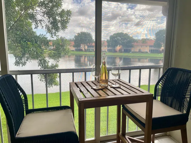 a view of a balcony with chairs and wooden floor