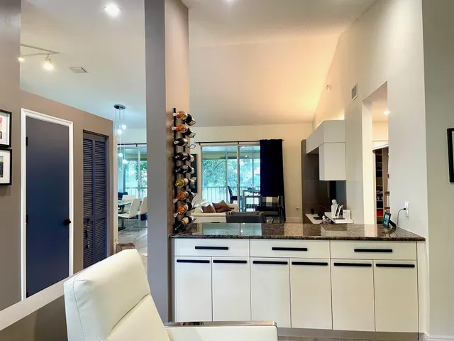 a kitchen with counter top space and living room view