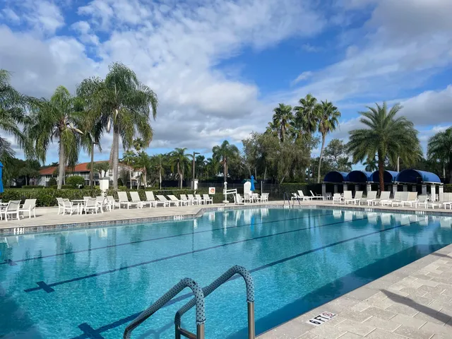 a view of swimming pool with outdoor seating and house in the background