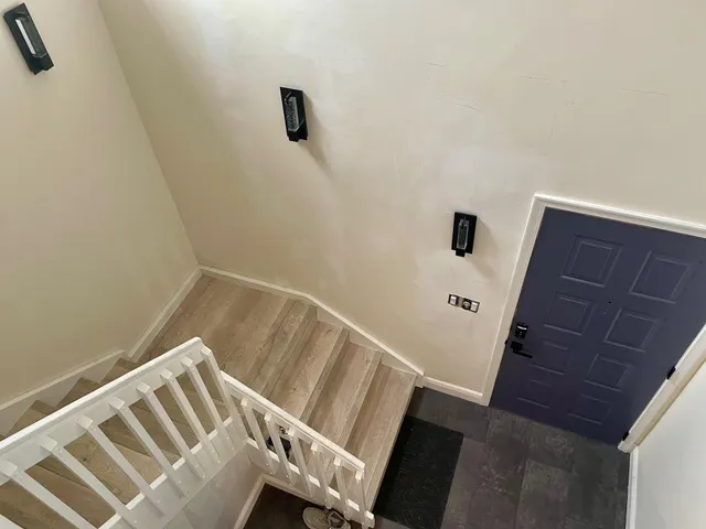 a view of stairs and an empty room with wooden floor