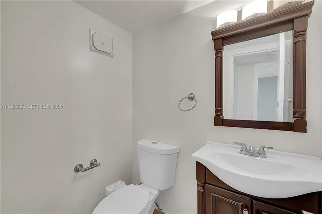 a bathroom with a toilet a sink and mirror