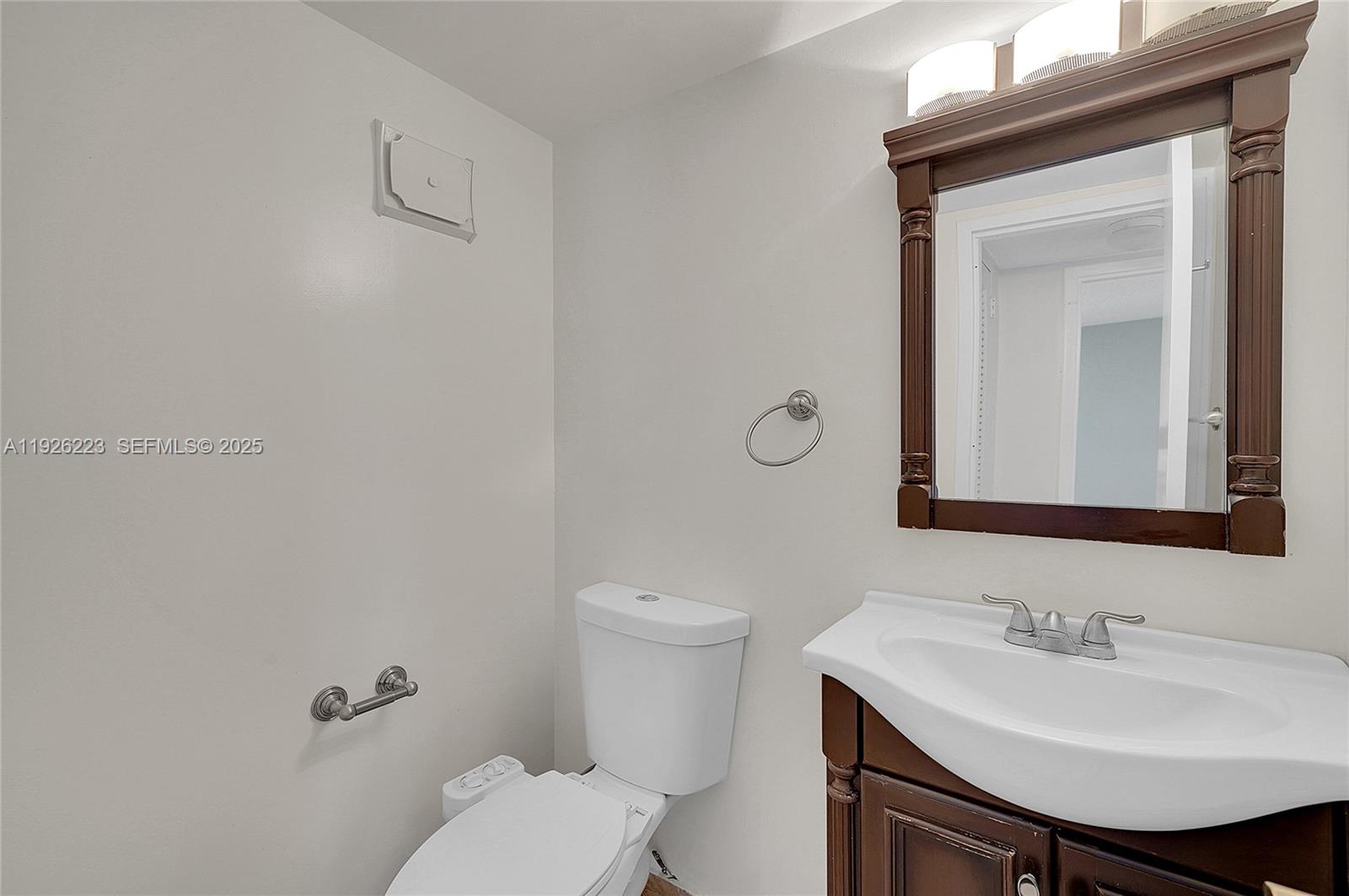 17800 Atlantic Boulevard, Unit 409 Sunny Isles Beach, FL 33160 - Photo 12 of 20 a bathroom with a toilet a sink and mirror