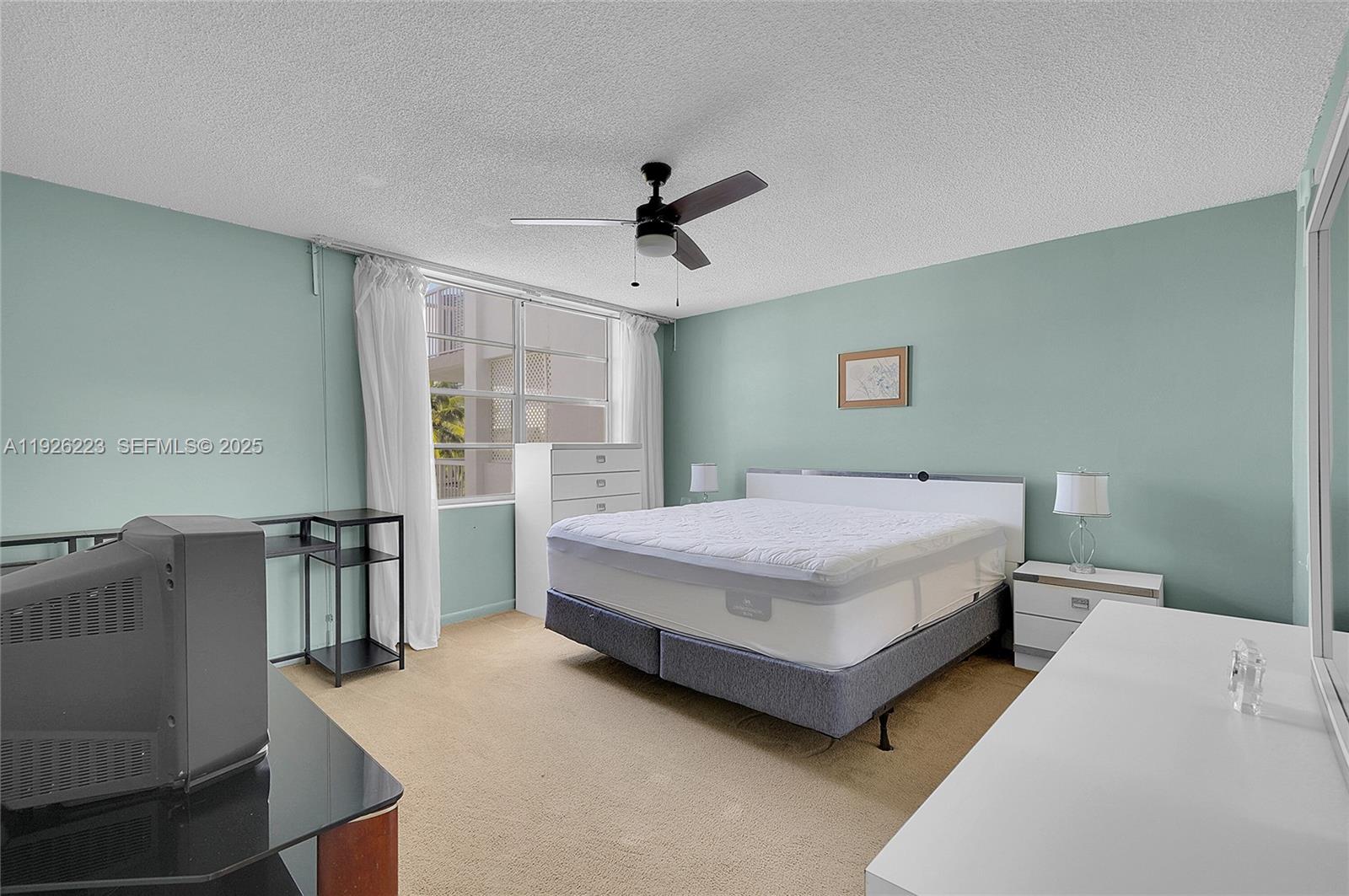 17800 Atlantic Boulevard, Unit 409 Sunny Isles Beach, FL 33160 - Photo 13 of 20 a bedroom with a bed dresser and a window