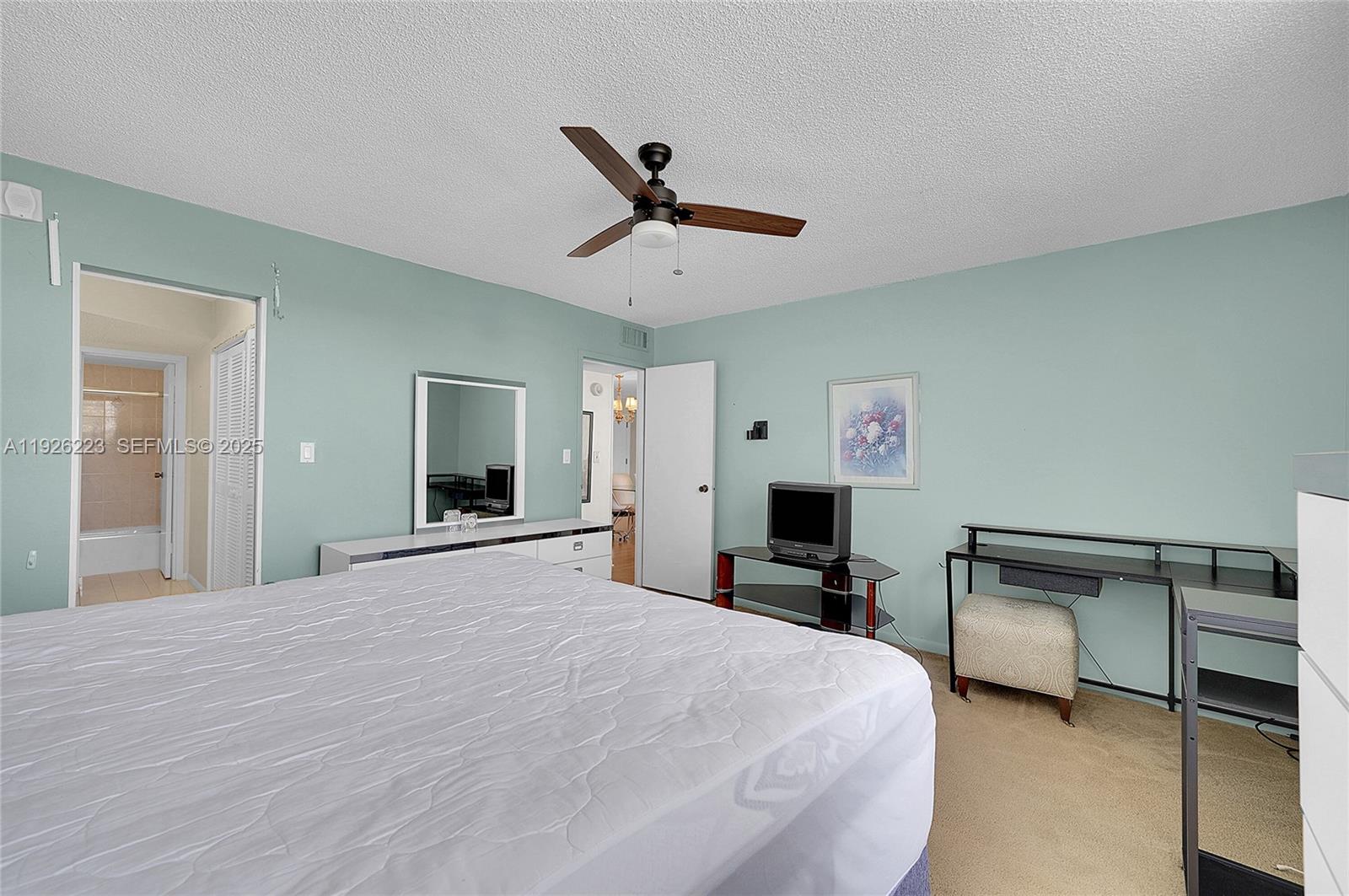 17800 Atlantic Boulevard, Unit 409 Sunny Isles Beach, FL 33160 - Photo 14 of 20 a bedroom with a bed and a chandelier