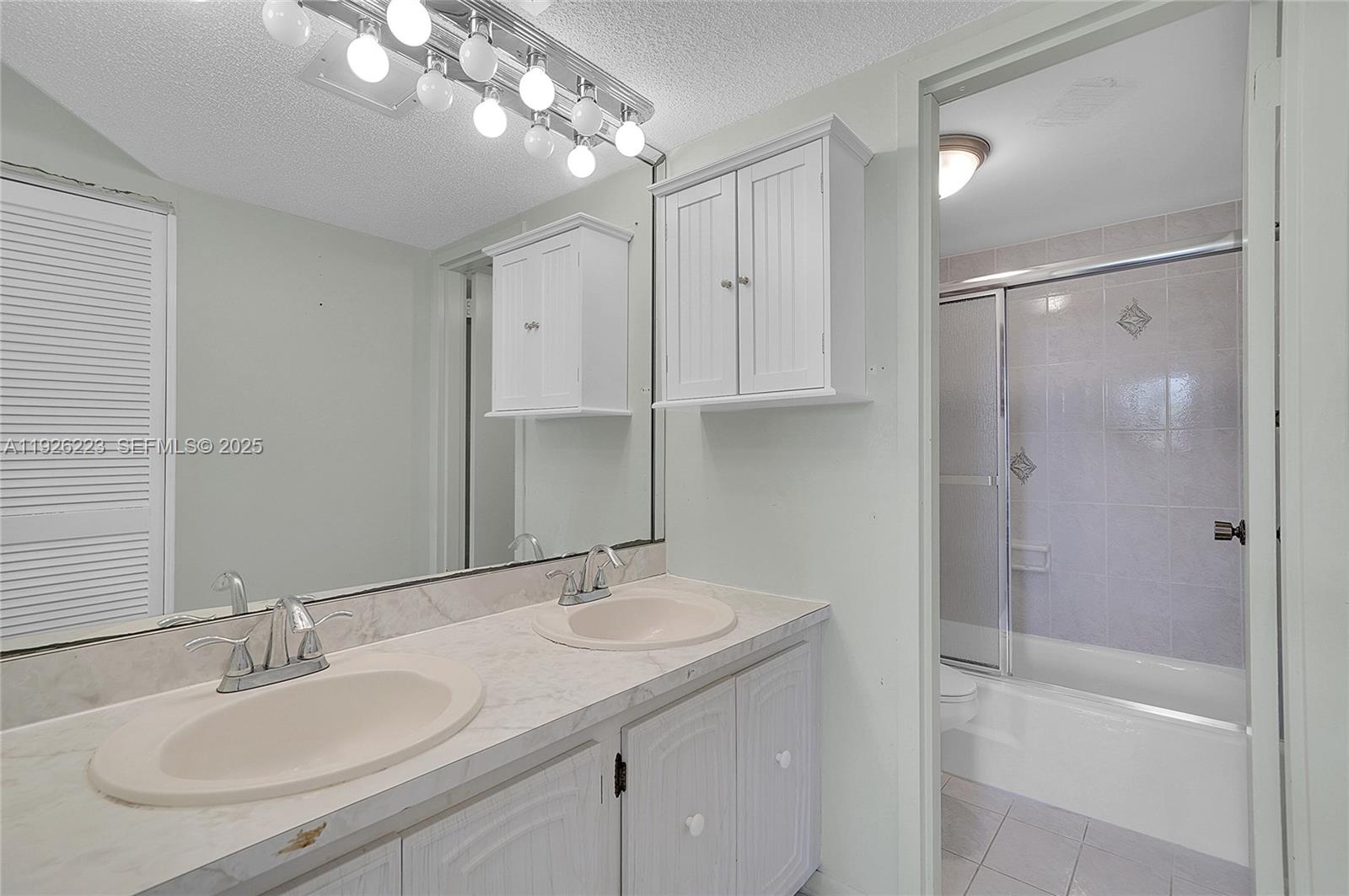 17800 Atlantic Boulevard, Unit 409 Sunny Isles Beach, FL 33160 - Photo 15 of 20 a bathroom with a sink double vanity and shower