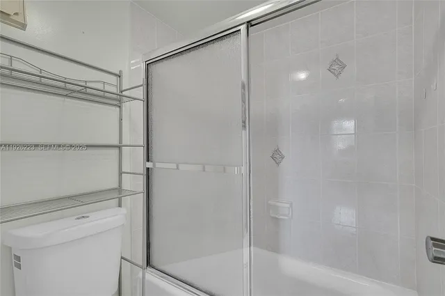 a bathroom with a shower and a glass door