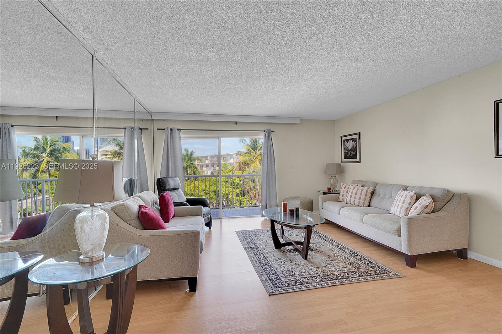 17800 Atlantic Boulevard, Unit 409 Sunny Isles Beach, FL 33160 - Photo 10 of 20 a living room with furniture and a large window
