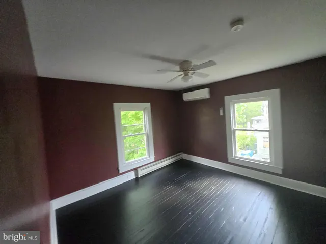a view of a hallway with wooden floor and stairs