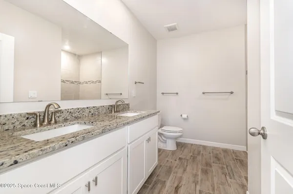 a bathroom with a granite countertop sink toilet and shower