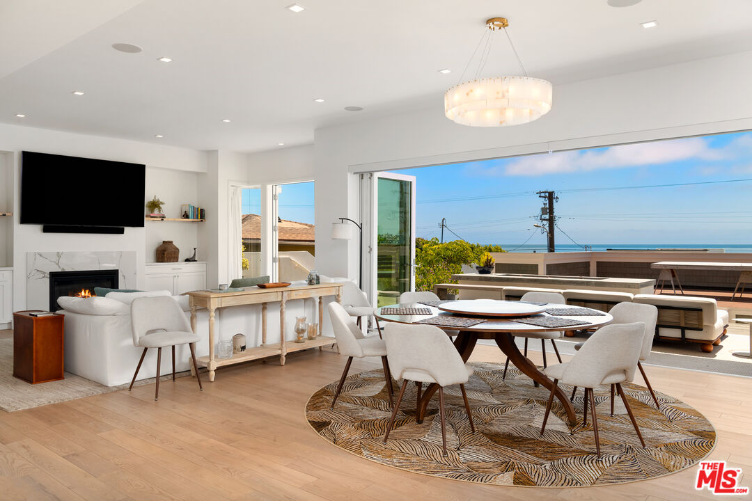 25157 Malibu Road Malibu, CA 90265 - Photo 6 of 33 a view of a dining room with furniture a fireplace and wooden floor