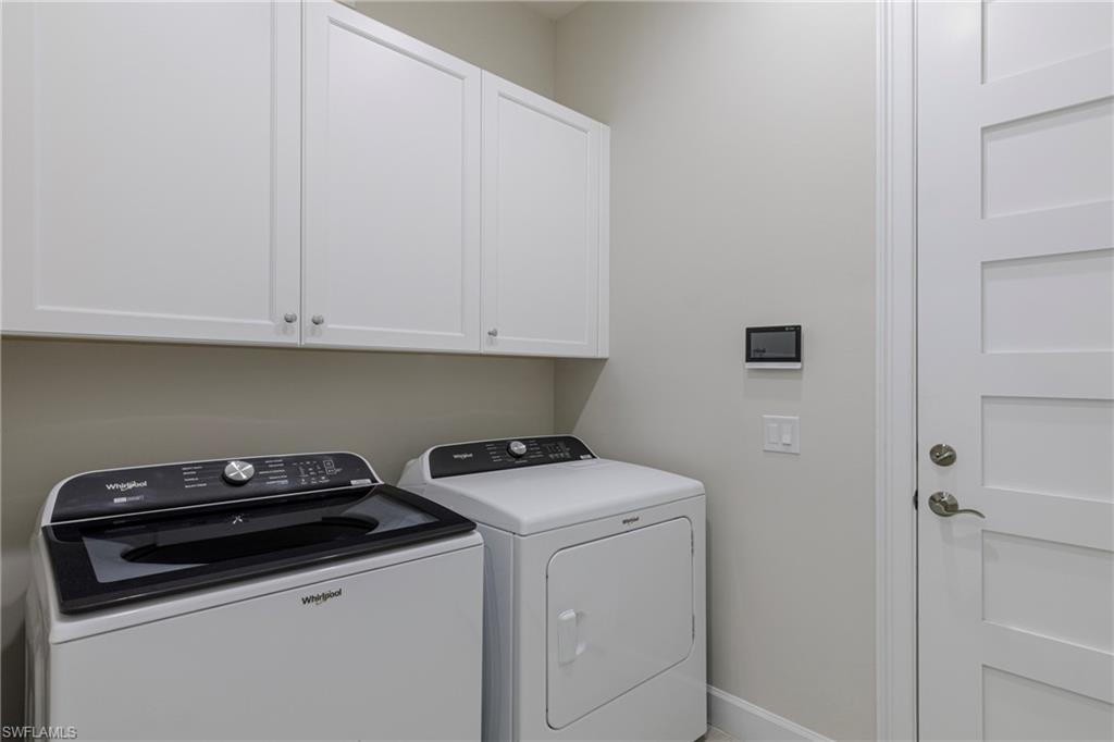 8909 Yucatan Court Naples, FL 34113 - Photo 17 of 36 Laundry room with washing machine and clothes dryer and cabinet space