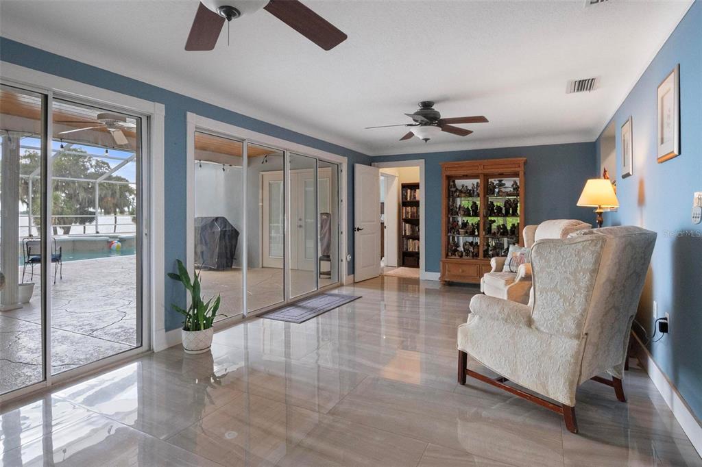 250 Brigham Road Northwest Winter Haven, FL 33881 - Photo 12 of 65 a living room with furniture and a floor to ceiling window