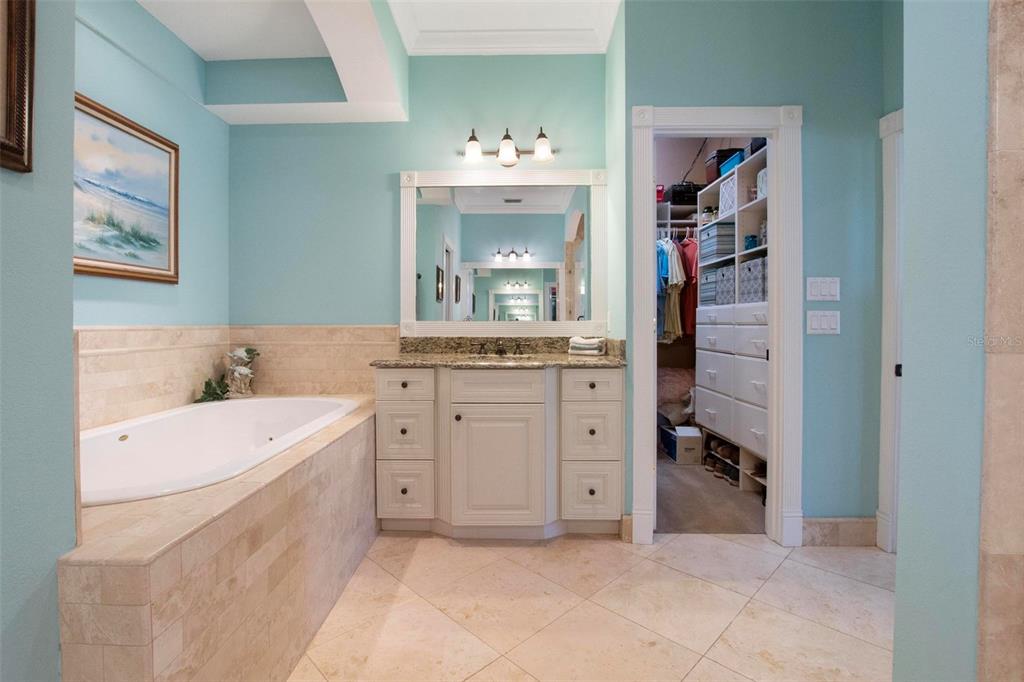 250 Brigham Road Northwest Winter Haven, FL 33881 - Photo 33 of 65 a spacious en suite bathroom with a double vanity sink a mirror and a bathtub