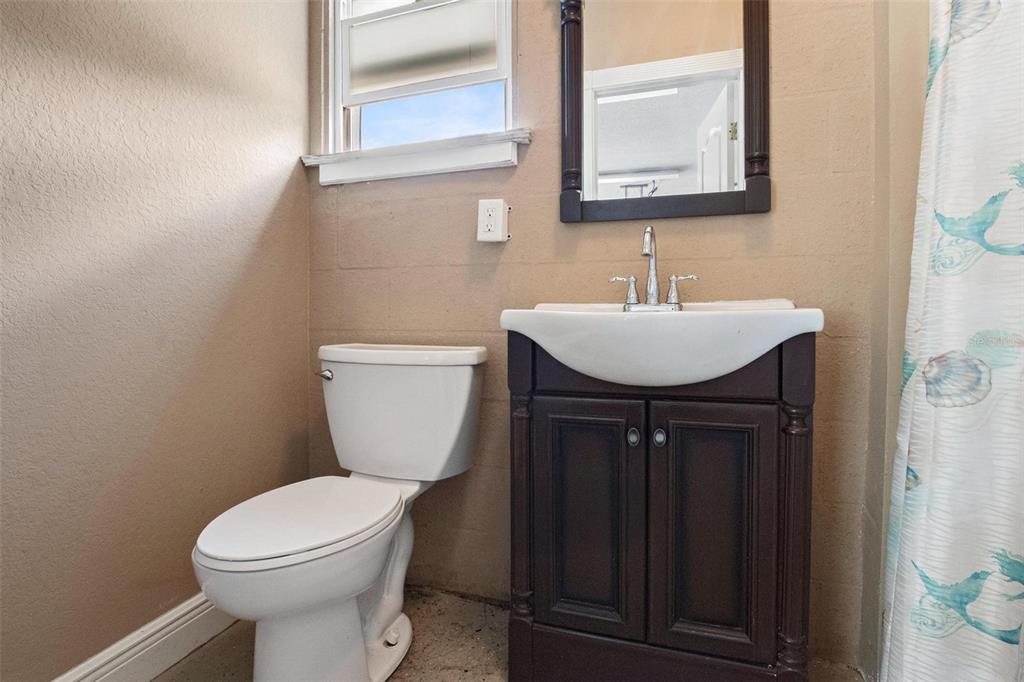 250 Brigham Road Northwest Winter Haven, FL 33881 - Photo 58 of 65 a bathroom with a toilet a sink a mirror and a window