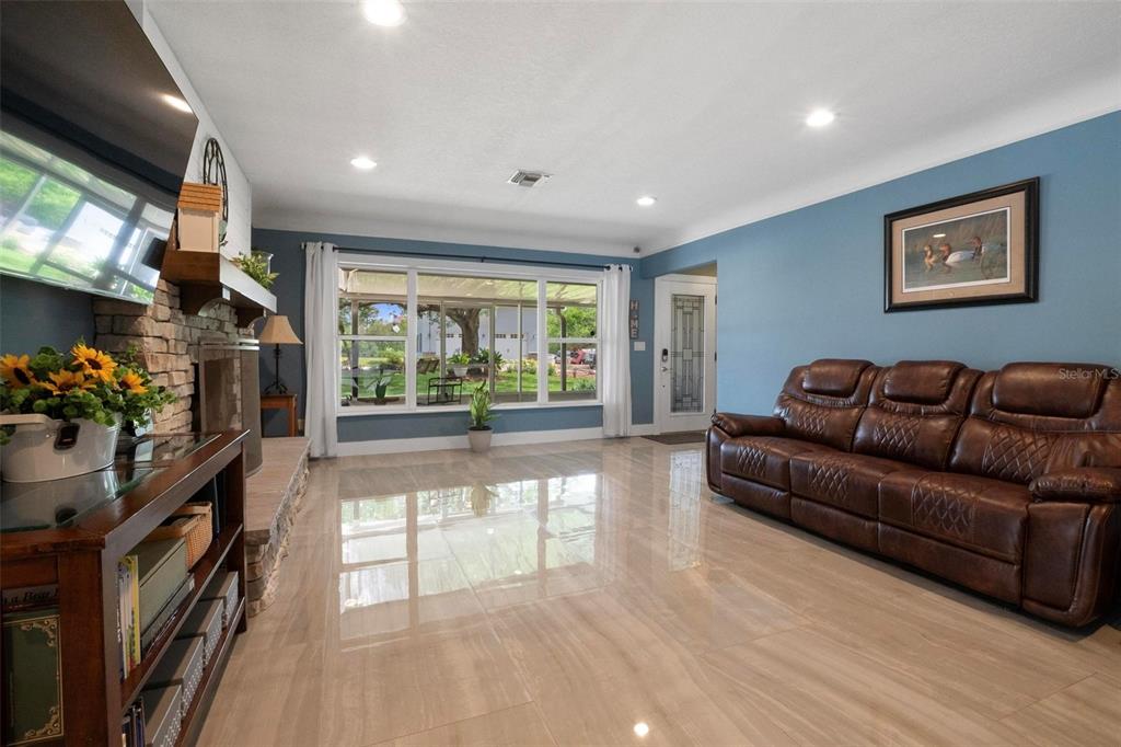 250 Brigham Road Northwest Winter Haven, FL 33881 - Photo 8 of 65 a living room with furniture a flat screen tv and a floor to ceiling window
