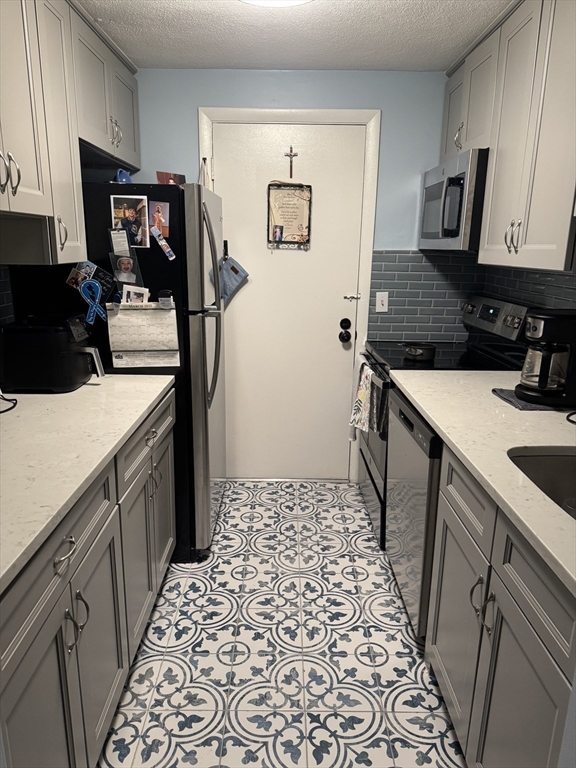 358 Broadway, Unit 13 Lynn, MA 01904 - Photo 6 of 26 a kitchen with a sink and a refrigerator