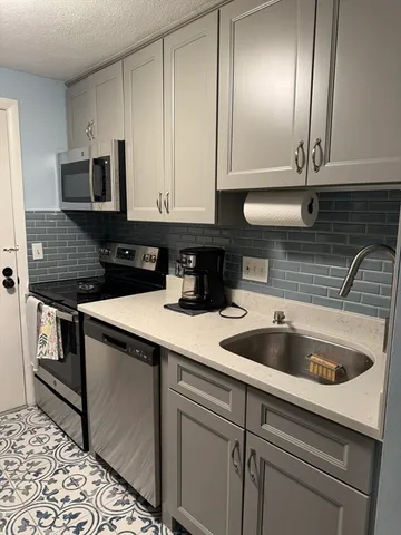 a kitchen with stainless steel appliances granite countertop a sink and a stove