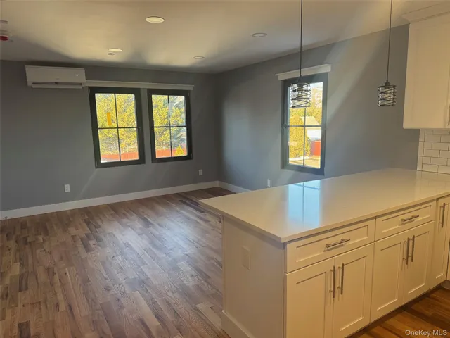 a kitchen with granite countertop white cabinets and wooden floor