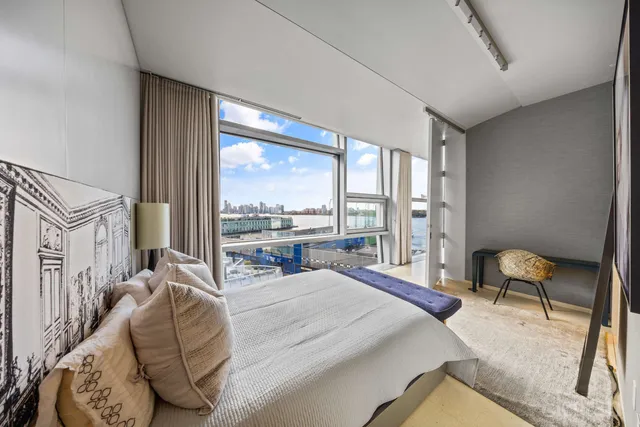 a bedroom with a bed and lamp on desk