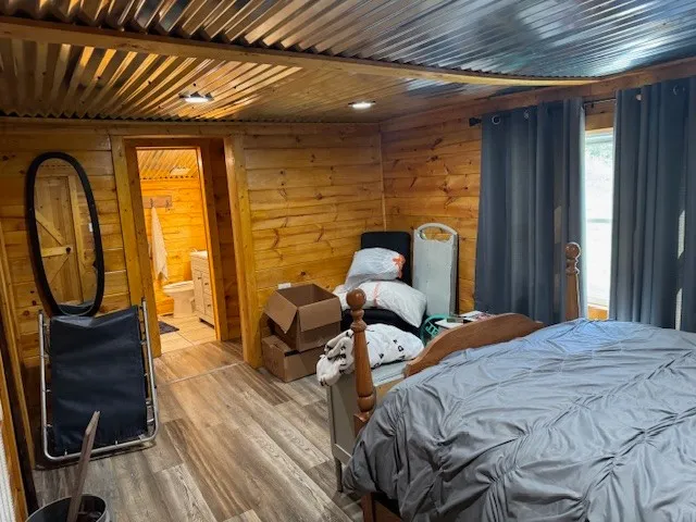 a bedroom with a bed and wooden floor