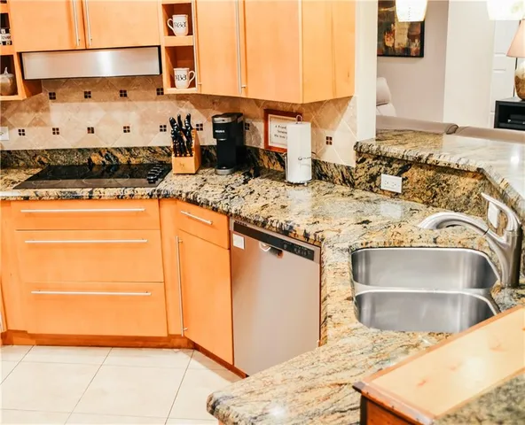 a kitchen with stainless steel appliances granite countertop a sink and a stove
