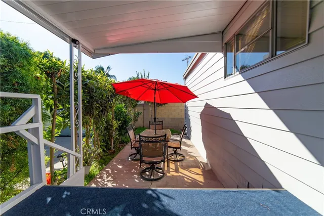 a view of a backyard with table and chairs under an umbrella